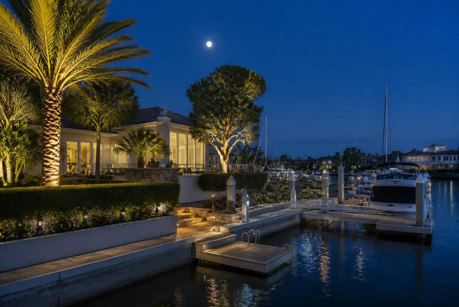 Dana Point waterfront home with a lit private dock at dusk