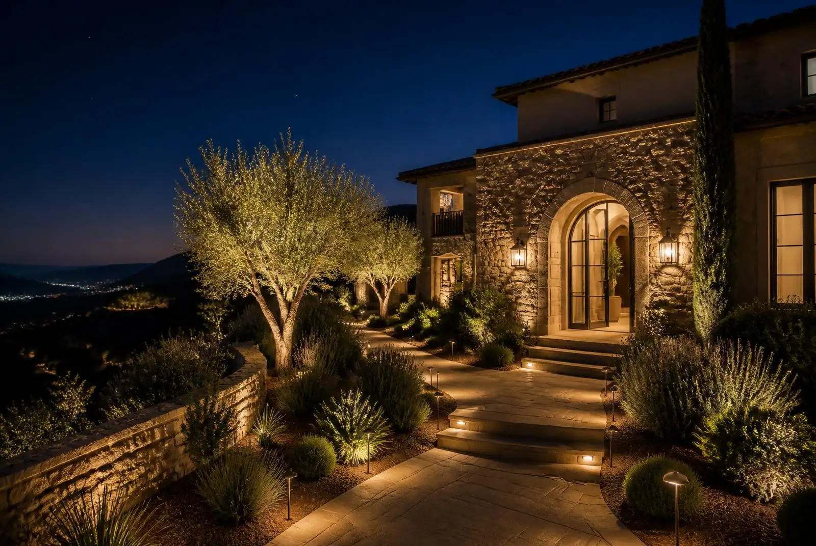 Laguna Niguel hillside Mediterranean home with uplit stone entry at night